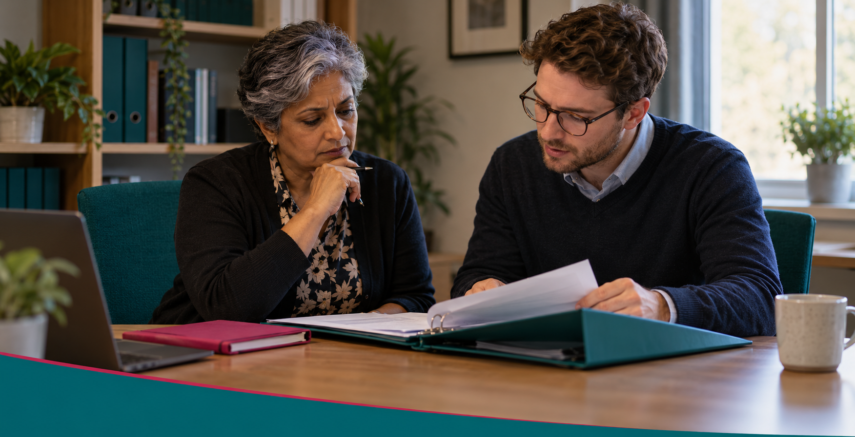 Two safeguarding colleagues review a confidential case file privately in an office.